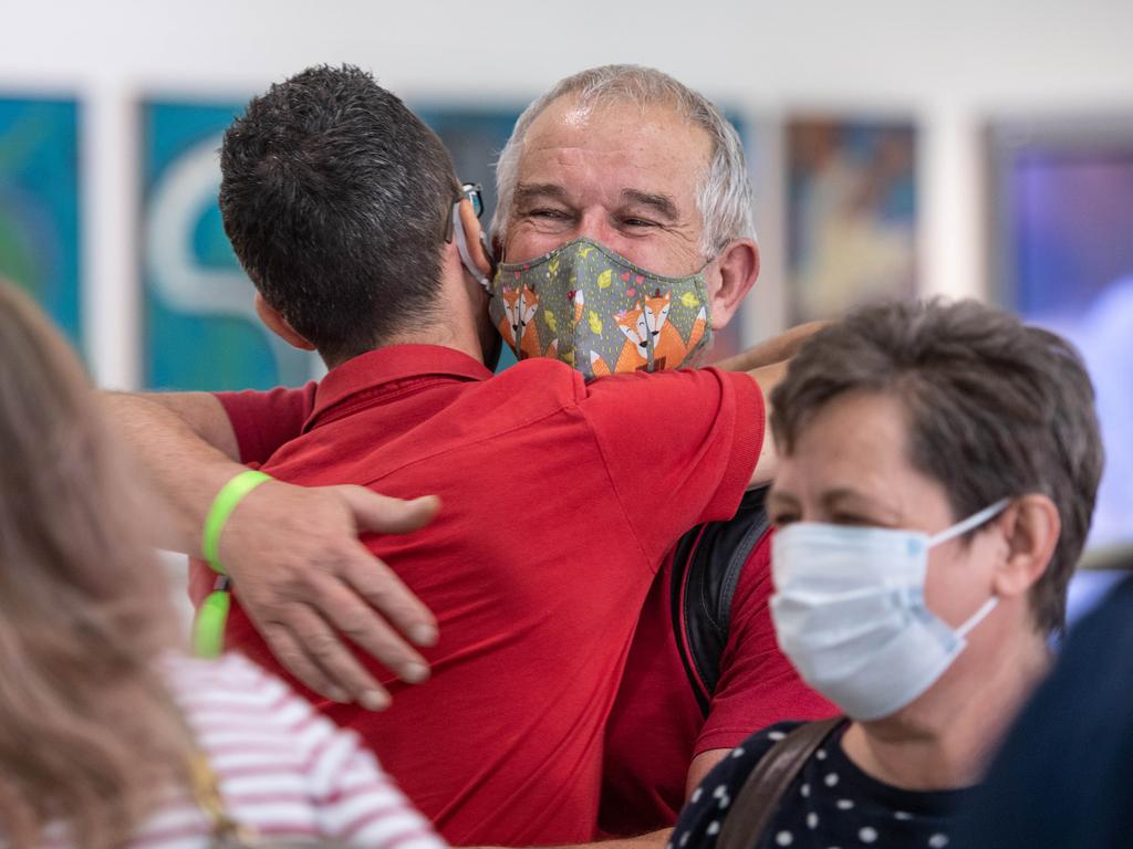 Rudolf Nemeth hugs son-in-law David Kaity at Brisbane International airport as borders re-open. Picture: Brad Fleet