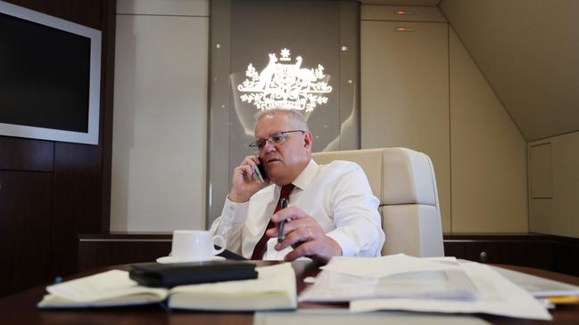 Prime Minister Scott Morrison on the phone to South Australian Premier Steven Marshall from the boardroom of the RAAF KC-30 on the way back from Japan. Picture: Adam Taylor