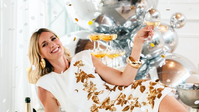 Coles Liquor ambassador Nikki Phillips popping open a bottle of Coles Liquor exclusive Canard-Duchêne champagne - a must in her household for NYE. Image: Supplied