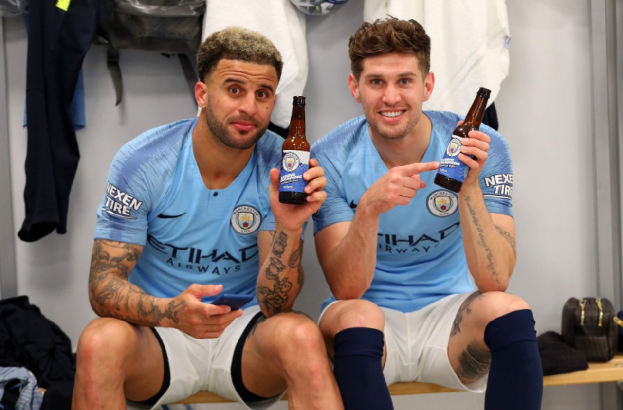 Manchester City players celebrate with their special 'Raining Champions' beer.