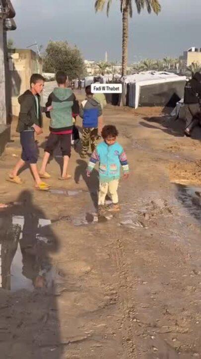 Displaced Children Wade Through Flooded Gaza Encampment