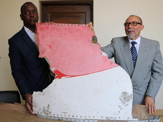 Joao de Abreu, right, President of Mozambique's Civil Aviation Institute (IACM), and a marshal display the suspected wreckage. Picture: Adrien Barbier/AFP