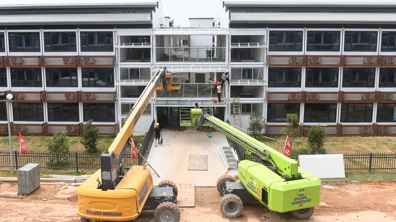 Staff members and engineering equipment in operation for the construction of the Guangzhou International Health Station. Picture: Lu Hanxin/Xinhua via Getty Images