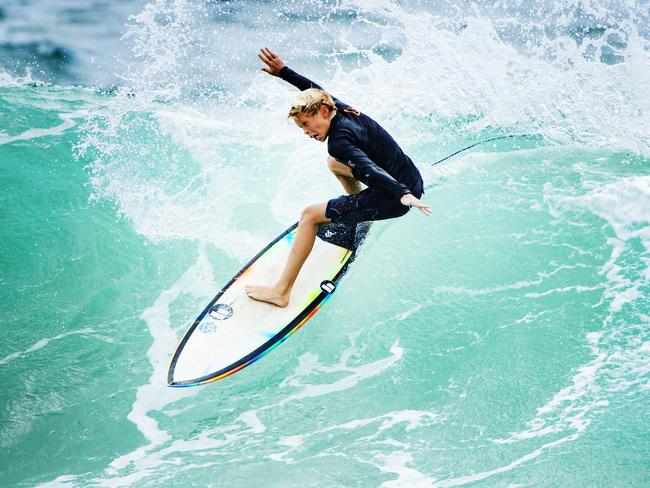 A young surfer makes the most of early surf conditions at Coolum as strong winds and rain hits the Sunshine Coast for Boxing Day. Picture: Lachie Millard