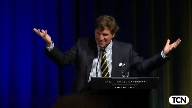 Tucker Carlson raises his hands in exasperation at the line of questioning.