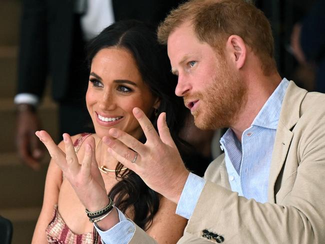 Britain's Prince Harry (R), Duke of Sussex, speaks with his wife Meghan Markle while attending a show during a visit to the National Centre for the Arts in Bogota on August 15, 2024. Prince Harry and his wife, American actress Meghan Markle, arrived in Colombia at the invitation of vice President Francia Marquez, with whom they will attend various meetings with women and young people to reject discrimination and cyberbullying. (Photo by RAUL ARBOLEDA / AFP)