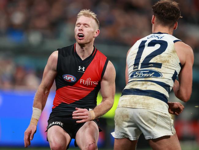 GEELONG, AUSTRALIA - JULY 15: Nick Hind of the Bombers reacts to contact from Jack Bowes of the Cats after the kick during the round 18 AFL match between Geelong Cats and Essendon Bombers at GMHBA Stadium, on July 15, 2023, in Geelong, Australia. (Photo by Kelly Defina/Getty Images)