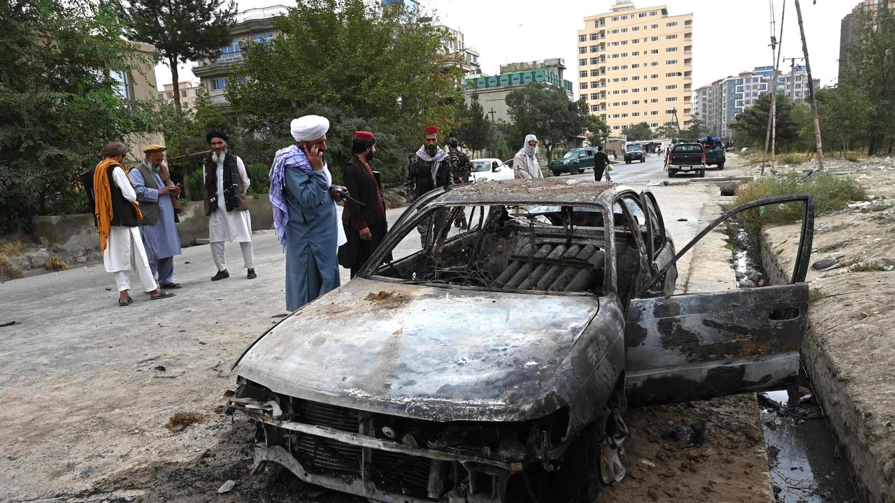 Taliban fighters investigate a damaged car after multiple rockets were fired in Kabul on August 30. Picture: Wakil Kohsar/AFP