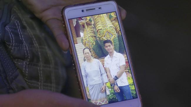 The aunt of coach Ekapol Chantawong shows a picture of him and his grandmother. Picture: AP.