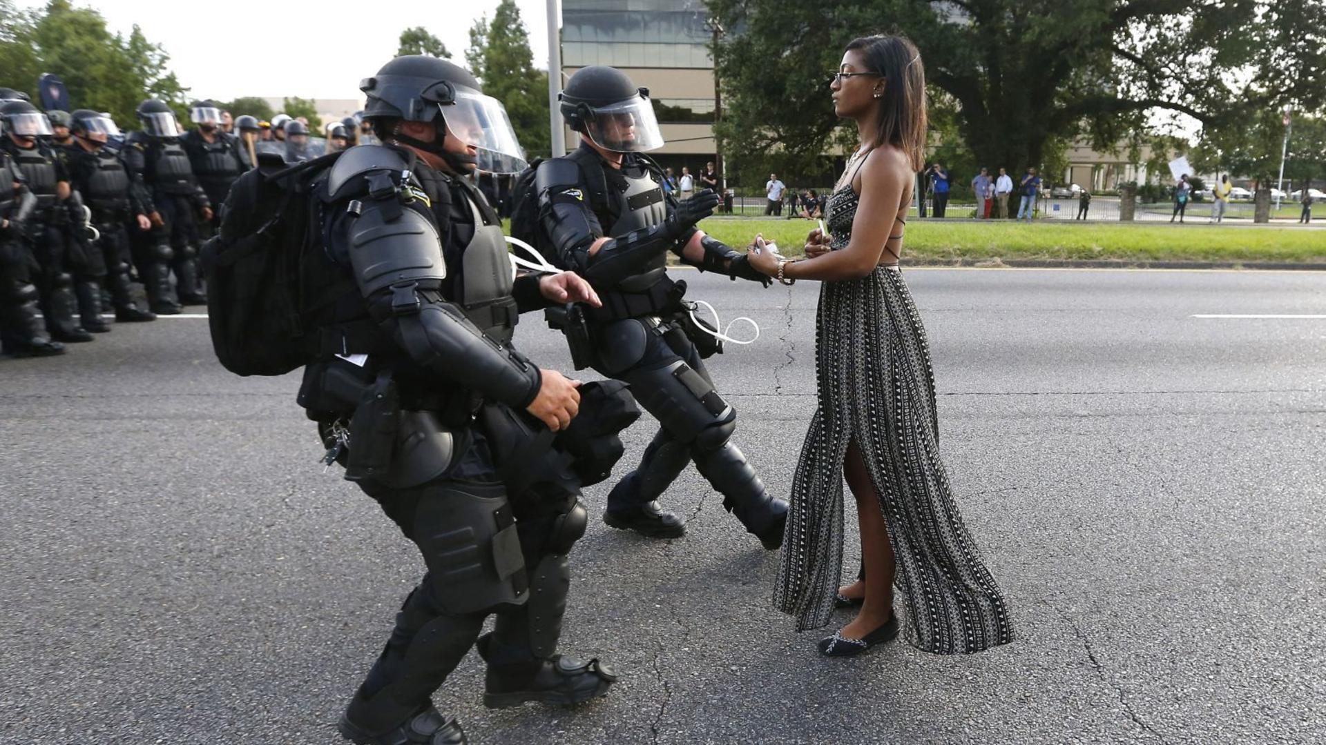 In this image released Monday Feb. 13, 2017 by World Press Photo titled "Taking A Stand In Baton Rouge" by photographer Jonathan Bachman for Thomson Reuters which won first prize in the Contemporary Issues, Singles, category of the World Press Photo contest shows lone activist, Leshia Evans, standing her ground while offering her hands for arrest as she is charged by riot police during a protest against police brutality outside the Baton Rouge Police Department in Louisiana, U.S.A., on 9 July 2016. (Jonathan Bachman/Thomson Reuters, World Press Photo via AP)