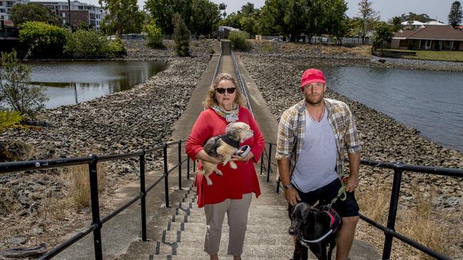 Residents like Annie Otton and Chris Humphrey used to love walking their dogs at the Racecourse Dr weir, which has now been blocked off with rocks. Picture: Jerad Williams