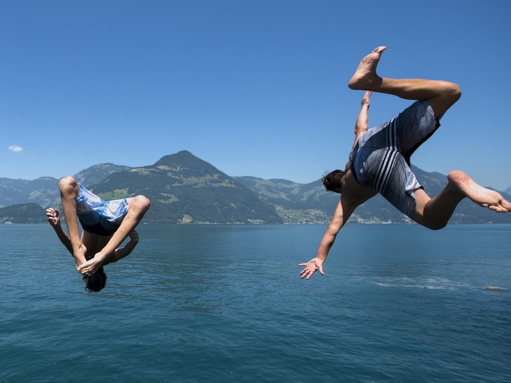 Young men jump into Lake Lucerne near Beckenried, Switzerland, on Wednesday, July 1, 2015. The European weather forecast is predicting high temperatures for the next few days. Picture: AP