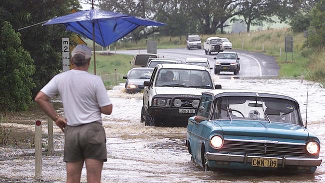 A man watches cars cross a flooded road during a weather event between Bangalow and Lismore in 2001. Photo: Adam Ward.