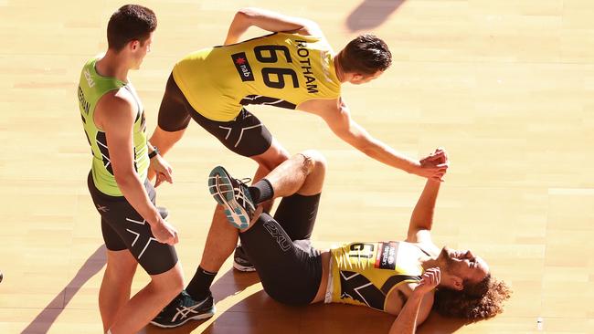 Griffin Logue is helped to his feet by Josh Rotham after competing in the Shuttle Run beep test during the 2016 AFL Draft Combine. (Photo by Scott Barbour/AFL Media/Getty Images)