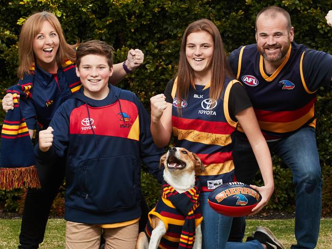 The Walsh family, Cindy, Luke, 13, Amber, 15, Dave and Rosie the dog pose for a picture in Crows colours in excitement for the upcoming Adelaide Crows finals at their family home in Sefton Park, Friday, Aug. 25, 2017. (AAP Image/MATT LOXTON)