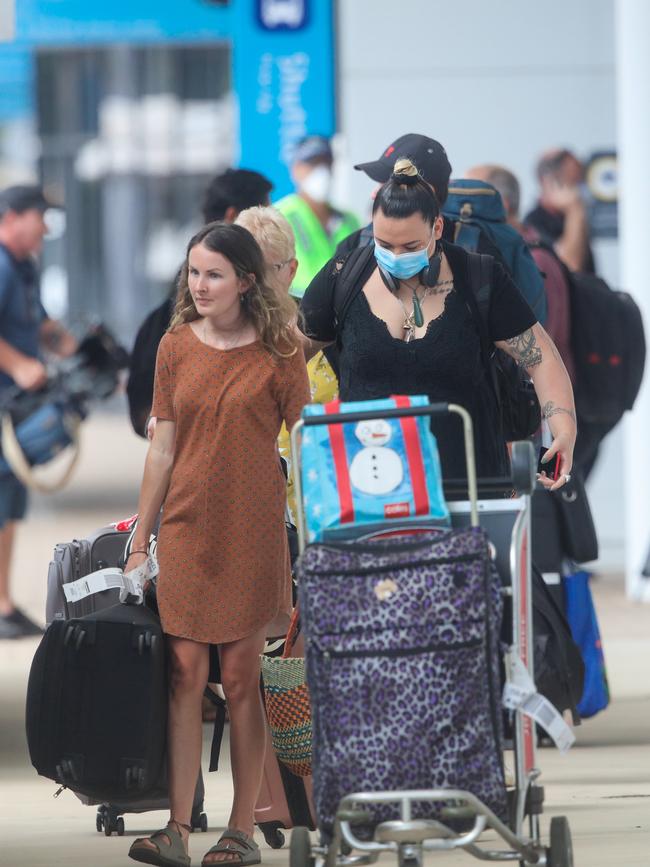 Two interstate travellers exit Darwin International Airport on Thursday. Picture Glenn Campbell