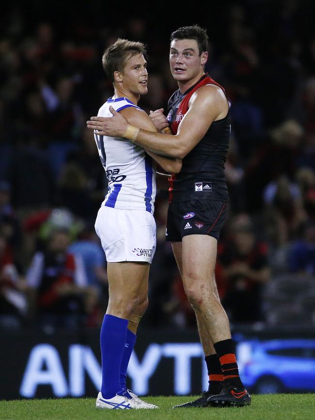 Nathan Grima embraces former Kangaroos teammate Andrew Swallow while playing for the Bombers in 2016. Picture: Colleen Petch