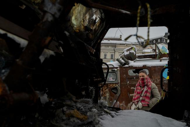 A woman looks at destroyed Russian military vehicles displayed in central Kyiv