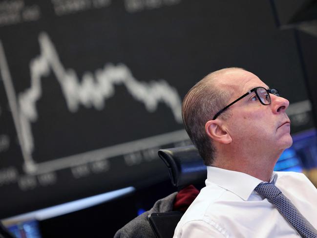 A trader works on front of a chart displaying Germany's share index DAX at the stock exchange in Frankfurt am Main, western Germany, on December 3, 2024. Germany's blue-chip DAX stock index jumped above 20,000 points for the first time following gains on US and Asian markets, defying multiple headwinds battering Europe's biggest economy. The DAX groups the 40 largest publicly-traded companies on the Frankfurt Stock Exchange. (Photo by Daniel ROLAND / AFP)