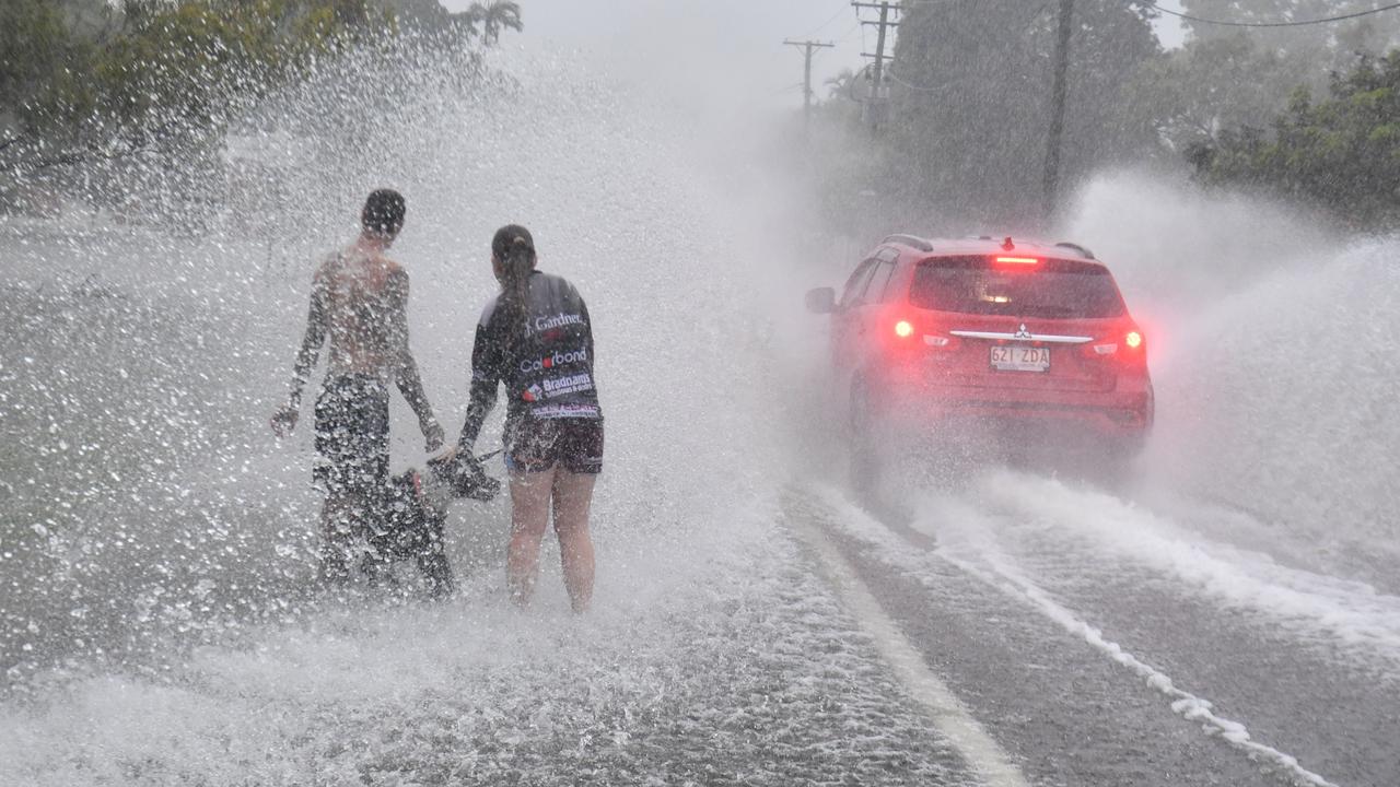 James Smith with Aden and pet dog Leroy on Bayswater Terrace, Hyde Park where they were warning drivers of water on the road. Picture: Evan Morgan