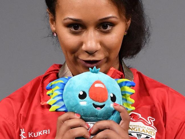 Silver medallist Zoe Smith of England kisses the 2018 Gold Coast Commonwealth Games mascot Borobi after the women's 63kg weightlifting event at the Carrara Sports Arena on the Gold Coast on April 7, 2018.  / AFP PHOTO / WILLIAM WEST