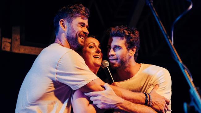 Chris Hemsworth, left and his brother Liam join Celeste Barber on stage in Byron Bay on Thursday. Picture: Diimex