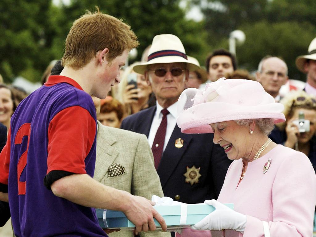 Queen Elizabeth II makes a presentation to Prince Harry after a polo match during Royal Ascot in happier times in 2003 in Windsor. Picture: Anwar Hussein/Getty Images