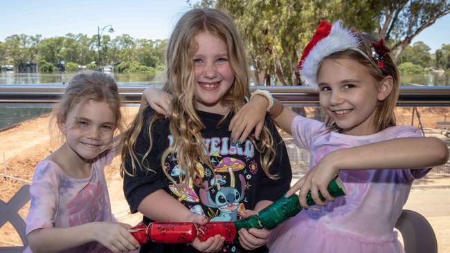 Cousins Scarlett Bridle, Kira McKeown and Violet Bridle pull bonbons after Christmas lunch at the Mannum Community Club. Picture Emma Brasier.