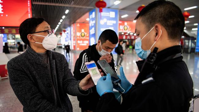 A passenger wearing a face mask shows a green QR code on his phone. Thje code signfies his health status to security upon arrival at Wenzhou railway station in Wenzhou. Picture: AFP