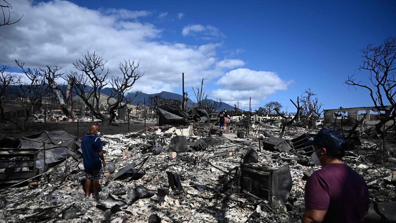 The Ganer family look through the ashes of their family home on Malolo Place in the aftermath of a wildfire in Lahaina. (Photo by Patrick T. Fallon / AFP)