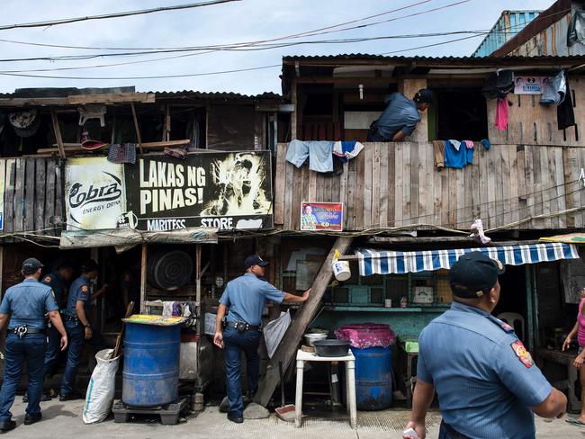 Police officers conduct an ‘Oplan Tokhang’ or house-to-house campaign on illegal drugs at a Manila slum on October 6, 2016. Picture: Noel Celis