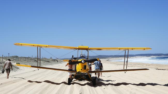 The 1942 Tiger Moth is towed through thick sand to a spot where it could be moved off the beach. Picture: Peter Lorimer