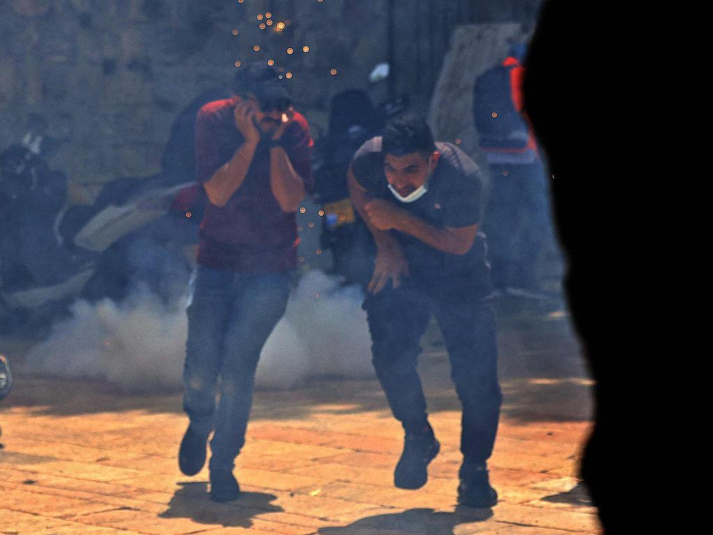 Palestinians run for cover from teargas fired by Israeli security forces in Jerusalem’s Old City on May 10. Picture: Emmanuel Dunand / AFP