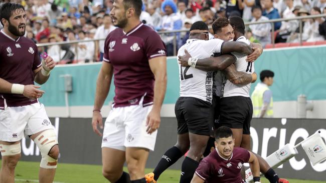 Fiji's Semi Radradra, right, is congratulated by teammates after scoring against Georgia. Pic: AP