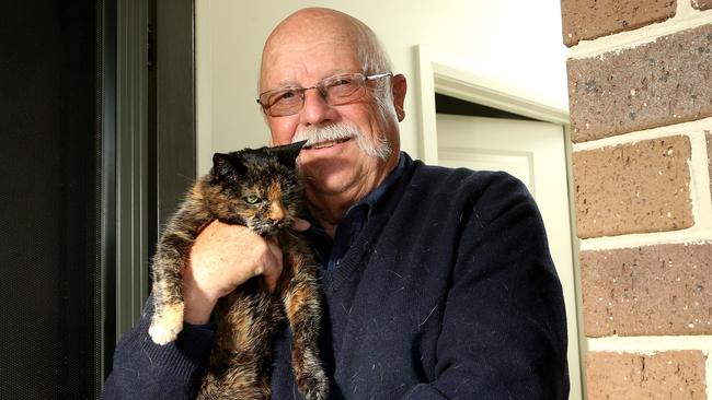 Phillip Walsh, with his cat Emma, doesn’t believe cats should be left in garages or sheds. Picture: Hamish Blair