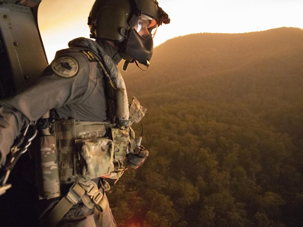 Royal Australian Navy Aircrewman Leading Seaman Ben Nixon of 808 Squadron, assesses a potential landing zone out of an MRH90 Taipan Military Support Helicopter. Picture: ADF