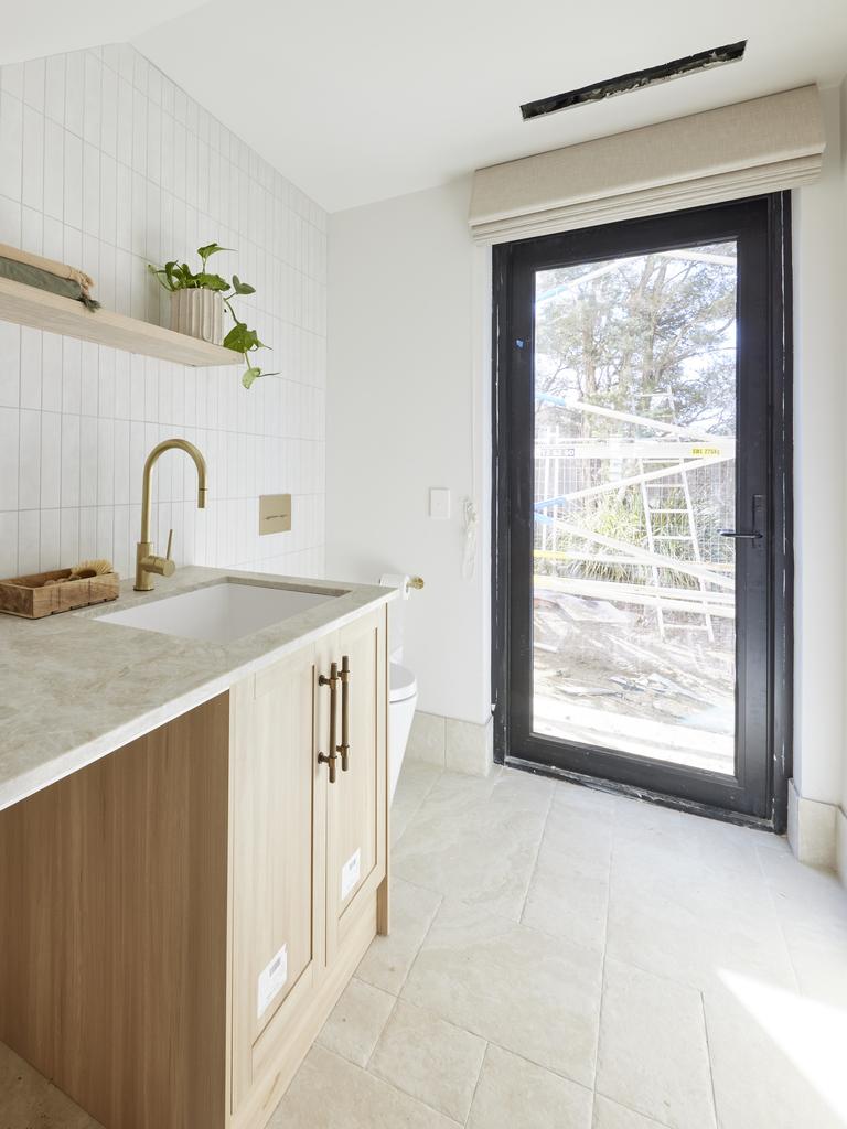 Their toilet, peeking out from next to a glass door.