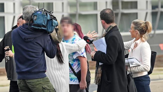 Family members of the alleged kidnappers abuse media crews outside Elizabeth Magistrates Court. Picture: Tom Huntley