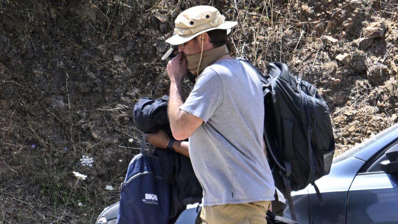 A mask-clad German police investigator leaves base camp after three days of testing. Picture: Getty