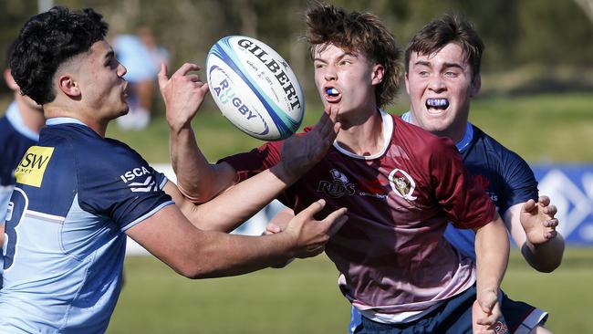 Waratahs' Malakye Enasio and Bailey Park tackle Qld Reds' Jacob Johnson.