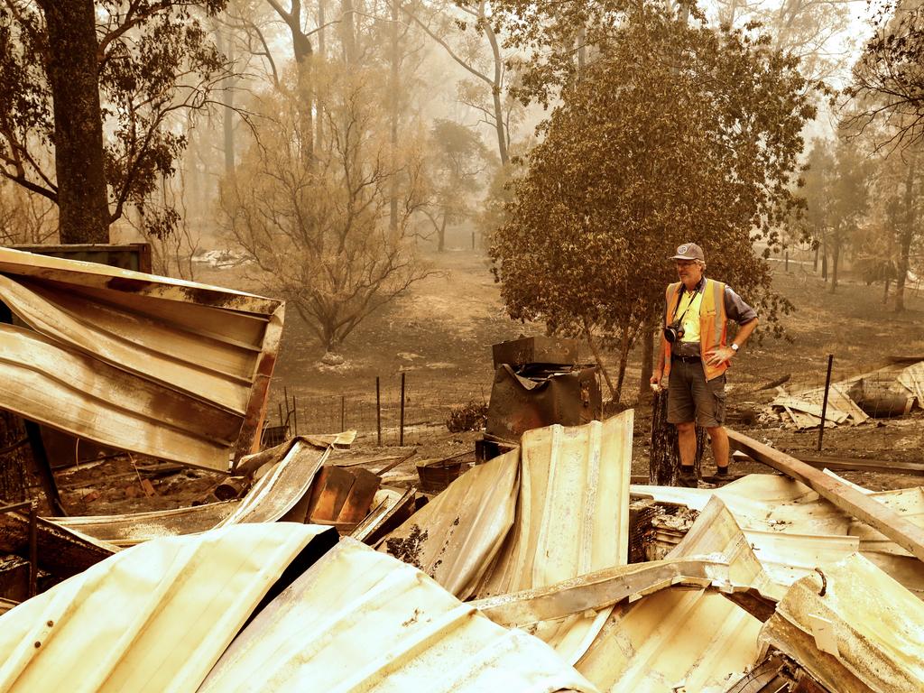 Victorian man Wayne Johnston inspects what’s left of his property in Sarsfield, near Mallacoota. Picture: Darrian Traynor/Getty Images