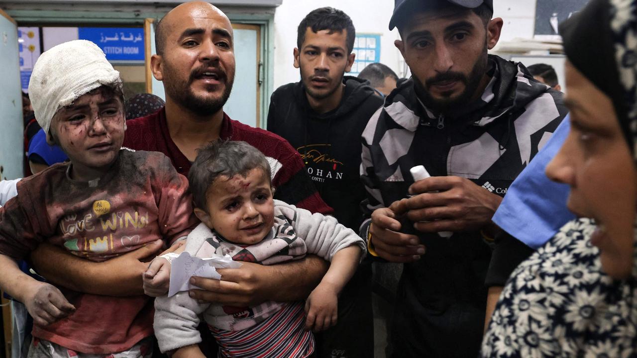 A man carries children injured in Israeli bombardment, at the al-Najjar hospital in Rafah in the southern Gaza Strip. Picture: AFP