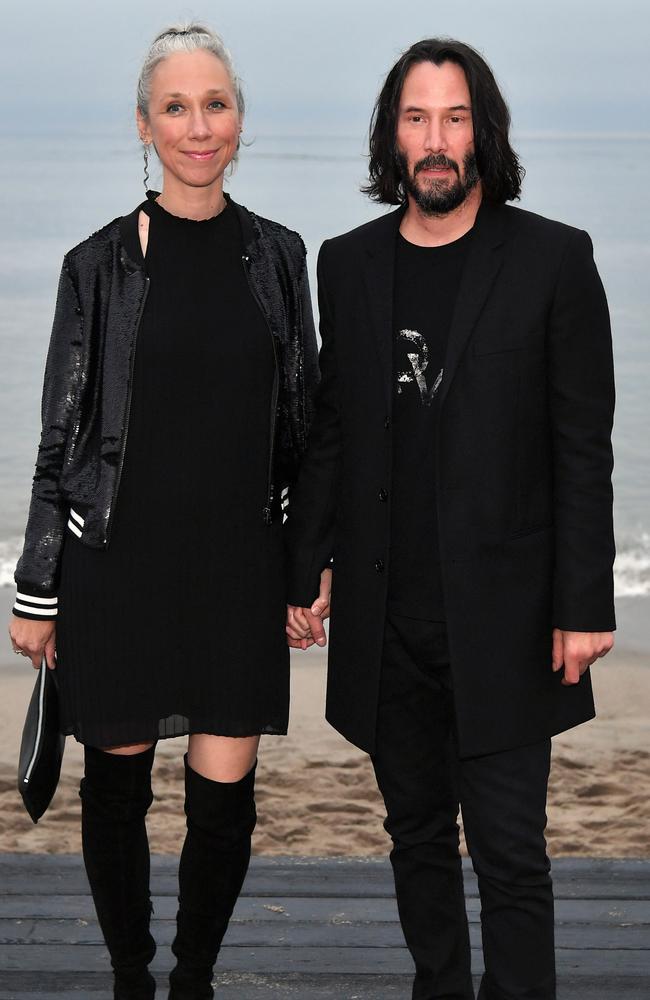 Grant and Reeves held hands at the Saint Laurent Spring Summer show in Malibu this June. Picture: Getty Images.