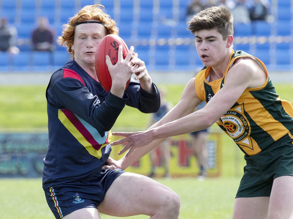 Guilford Young College’s Dom White, left, spins out of trouble during the SATIS grand final against St Patrick’s College. Picture: Chris Kidd