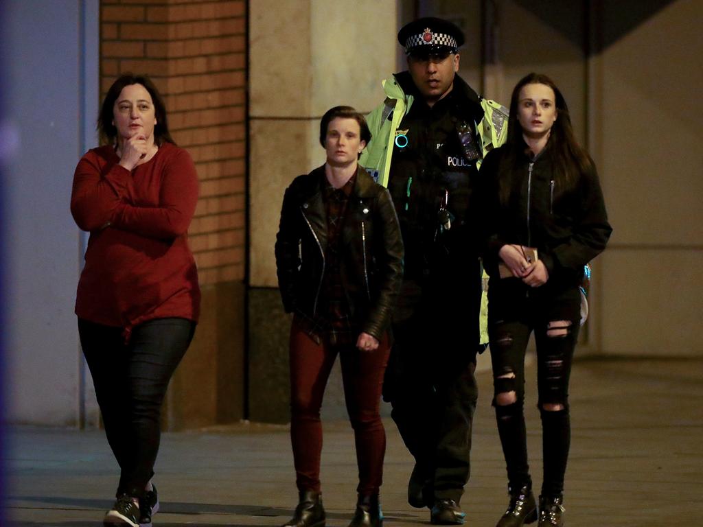 A police officer escorts people near to Manchester Arena on May 23, 2017 in Manchester, England. Picture: Getty