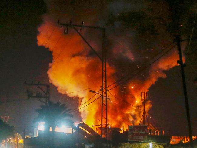 This handout picture provided by the United Nations Relief and Works Agency for Palestine Refugees in the Near East (UNRWA), shows fire and smoke billowing from the site of an Israeli air strike around tents for displaced people inside the walls of Al-Aqsa Martyrs Hospital in Deir al-Balah, in the central Gaza Strip early on October 14, 2024. (Photo by United Nations Relief and Works Agency for Palestine Refugees (UNRWA) / AFP) / === RESTRICTED TO EDITORIAL USE - MANDATORY CREDIT "AFP PHOTO / HO / UNRWA"- NO MARKETING NO ADVERTISING CAMPAIGNS - DISTRIBUTED AS A SERVICE TO CLIENTS ===