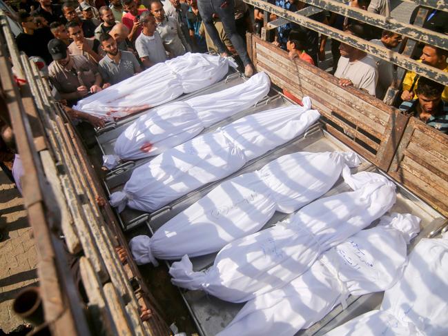 Mourners look at the covered bodies of the Abu al-Rish family, killed during an Israeli air strike in Khan Yunis, on the southern Gaza Strip. (Photo by SAID KHATIB / AFP)