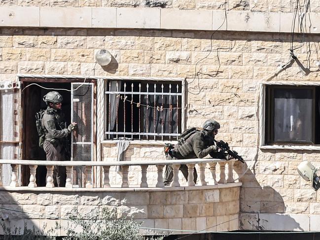 Israeli army soldiers take position during a raid in Qabatiyah. Picture: AFP