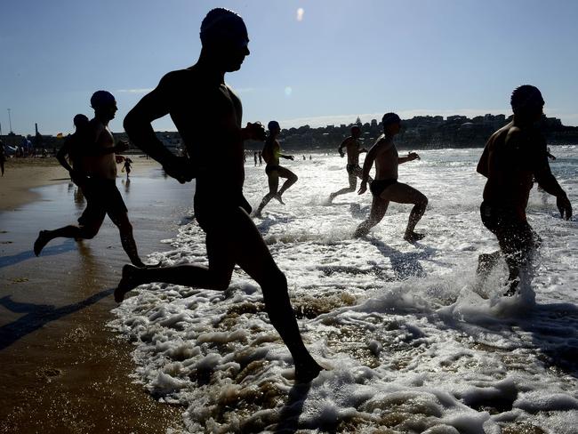 A wave of competitors hit the water at the start of the 1km swim. Picture: John Appleyard