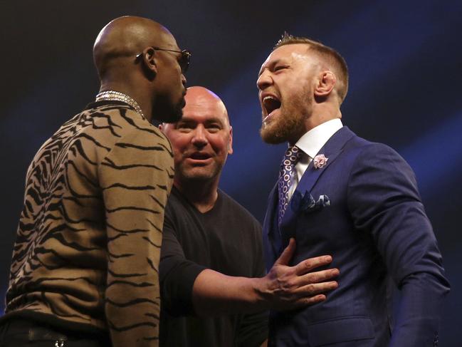 Boxers Connor McGregor, right and Floyd Mayweather left, are separated by UFC President Dana White, during a press conference to promote their upcoming fight, at the SSE Arena, in Wembley, London,  Friday July 14, 2017. (Scott Heavey/PA via AP)